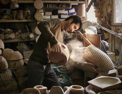 Guillaume Dubosq sculptant un saladier en bois d'olivier dans son atelier 